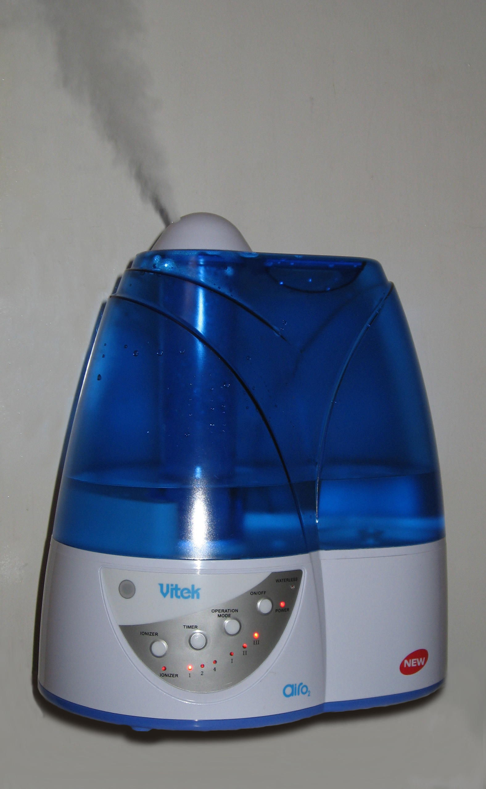 Blue ultrasonic humidifier releasing visible mist